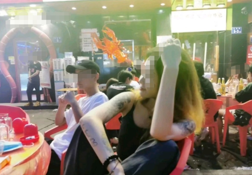 街边摊聚餐姑娘"坐姿"成焦点,纹身花臂凸显个性,隔壁小伙拍照惹麻烦