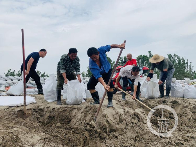 7月13日,江西九江市江洲镇,当地村民正在装沙袋堤坝修筑.