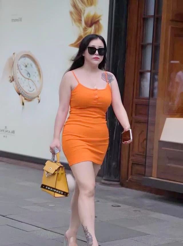 胖美女橙红色穿搭.花臂吊带小挎包.走在大街上象一幅画