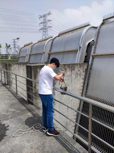 监测人员对中心河泵站河水进行现场采样