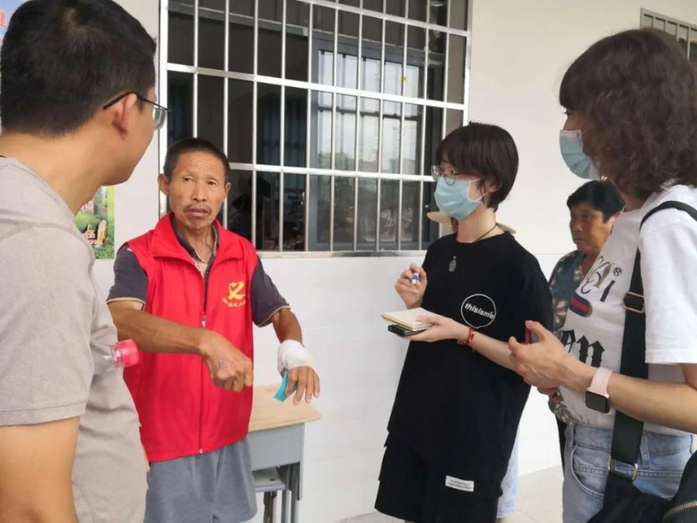 7月17日,报社记者叶奕宏(右二)与驻地记者李傲(左一)在洪湖围堤旁采访