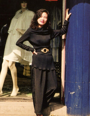 80年代的中国女性:服装店门口,穿着很色衣服的时尚美女.