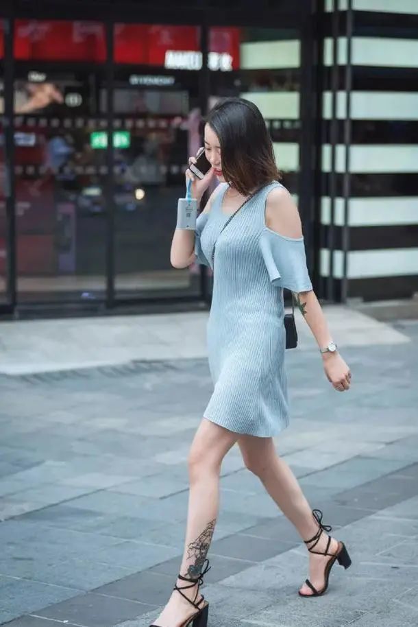美女一件蓝色的旗袍高开叉的设计让她走路,露出双腿若