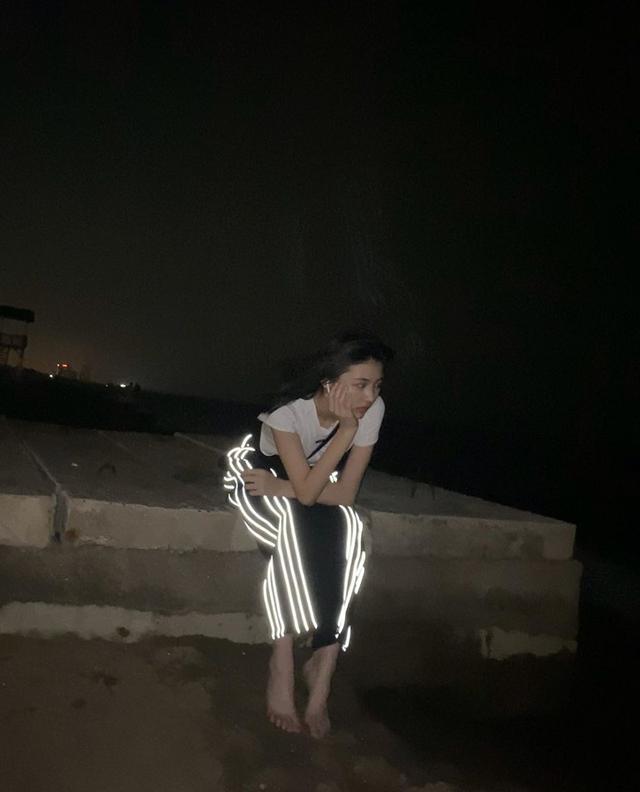 她独自赤脚坐在楼顶想心事,光脚踩地不嫌脏,夜光裤子像盏灯,表情有些