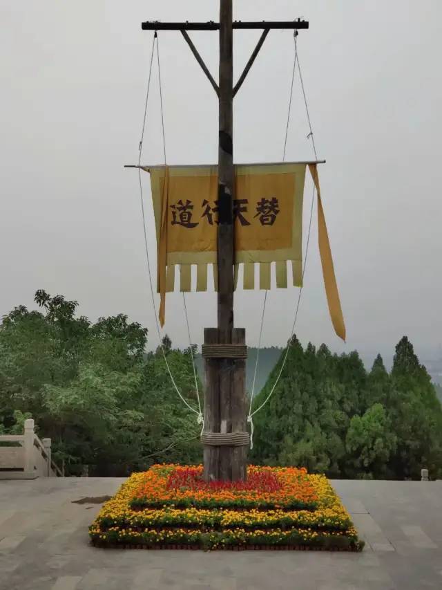 堂前广场竖着三根旗杆,当中的一根挂着黄旗,旗上"替天行道"随风飘扬