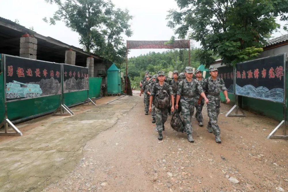 驻训场两侧写满了欢迎抗洪官兵凯旋的标语"洪水不退,我们不退!