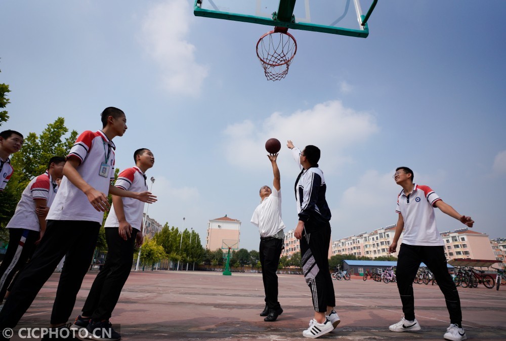 河北省黄骅市第三中学教师李福龙(右三)在课间和学生打篮球