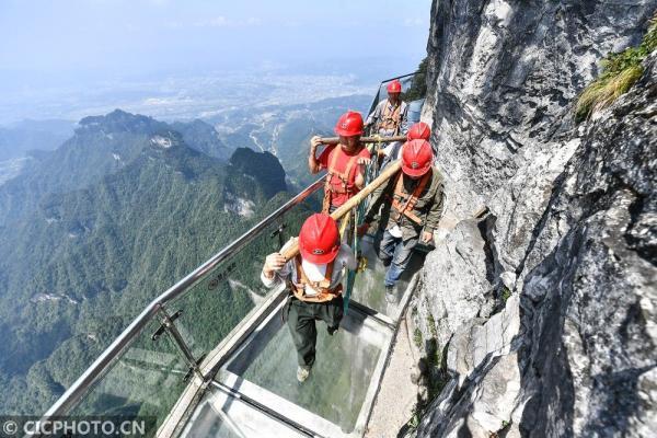 以上图片:施工人员在湖南省张家界市天门山景区对西线玻璃栈道的玻璃