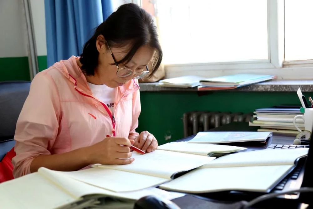 青铜峡市沈闸中心小学教师马丽燕在课间批改作业.