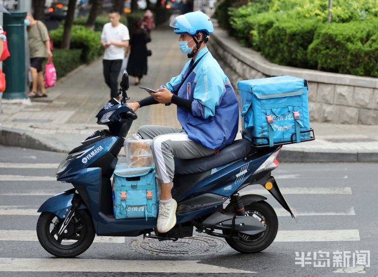 外卖小哥边骑车变操作手机接单.