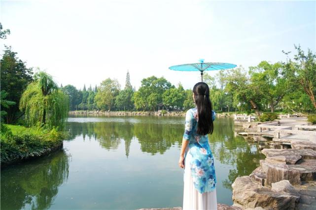 撑着油纸伞的江南女子,静静的站在东湖畔远眺,婉约成一道亮丽的风景