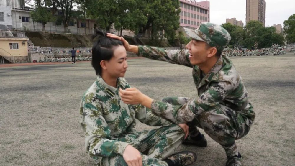 起因是张教官给一个小萌新重新扎了散掉的头发真正的现场图小萌新的