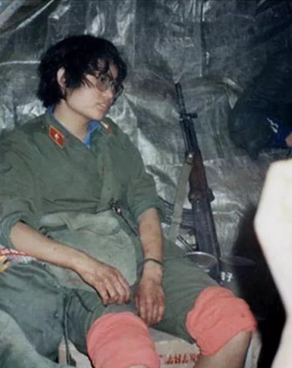 紧张救护伤员后,刘亚玲在猫耳洞中满脸疲惫,手部血迹未干