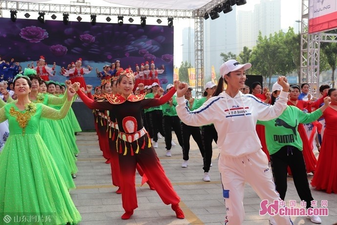 伴随着一曲《百花香,菏泽市快乐舞步健身操协会会长康建丽带领8只