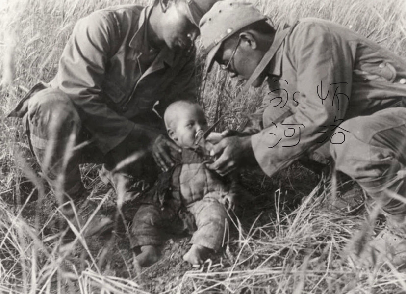 这是两名日军在给一个中国幼儿喂食的照片,拍摄时间是1938年.