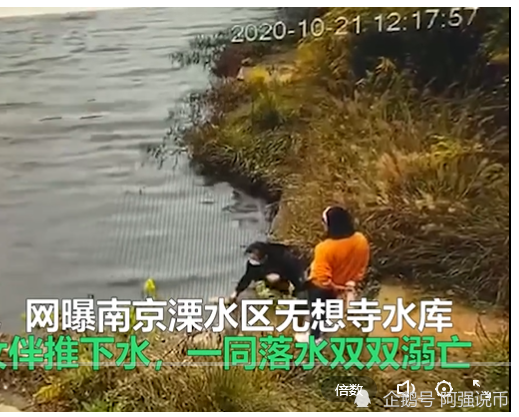 女子在水库边上系鞋带，被身后同伴推入水里