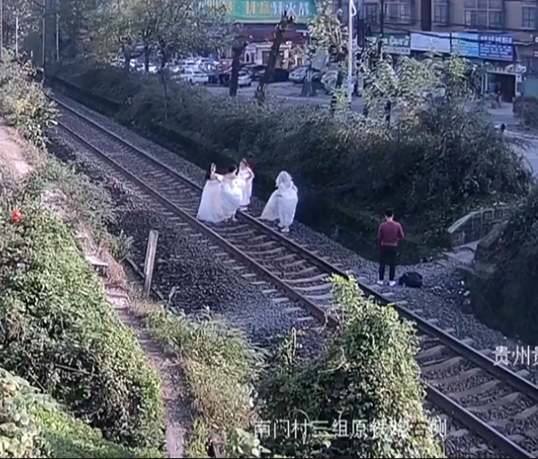 为了能拍出有文艺气息的照片,摄影师让女子穿婚纱上铁轨