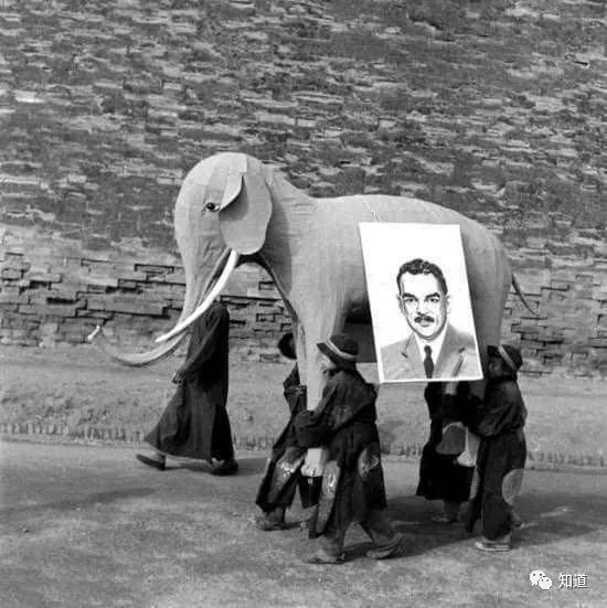 1948年北平城里抬着共和党候选人杜威画像和纸糊大象的造势