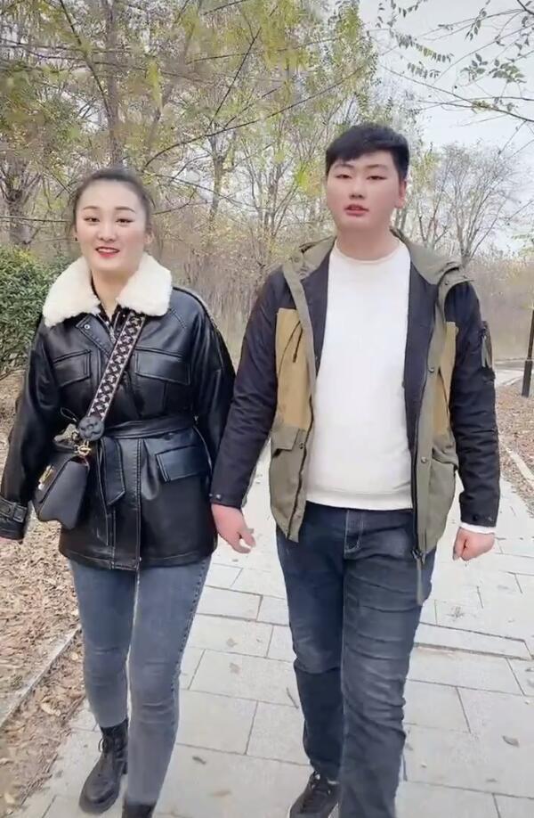 大衣哥儿子儿媳牵手逛公园,亚男穿皮衣暴露身材,腰粗腿粗吃胖不少