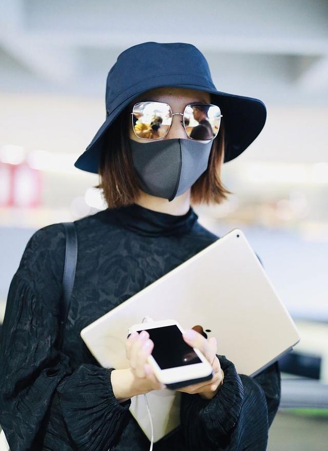 王珞丹帽子口罩墨镜包裹严实很低调,手上抱着手机电脑