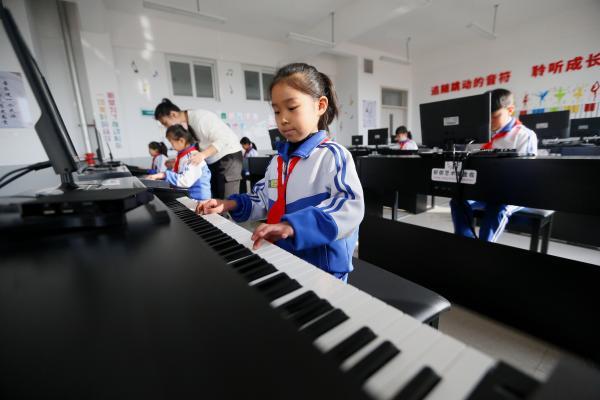 12月1日,山东省青岛市即墨区龙山中心小学钢琴社团的学生在弹钢琴.