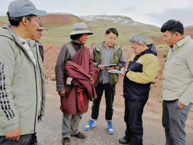 在贡觉县阿旺乡路遇建档立卡户牧人丹增(左三)