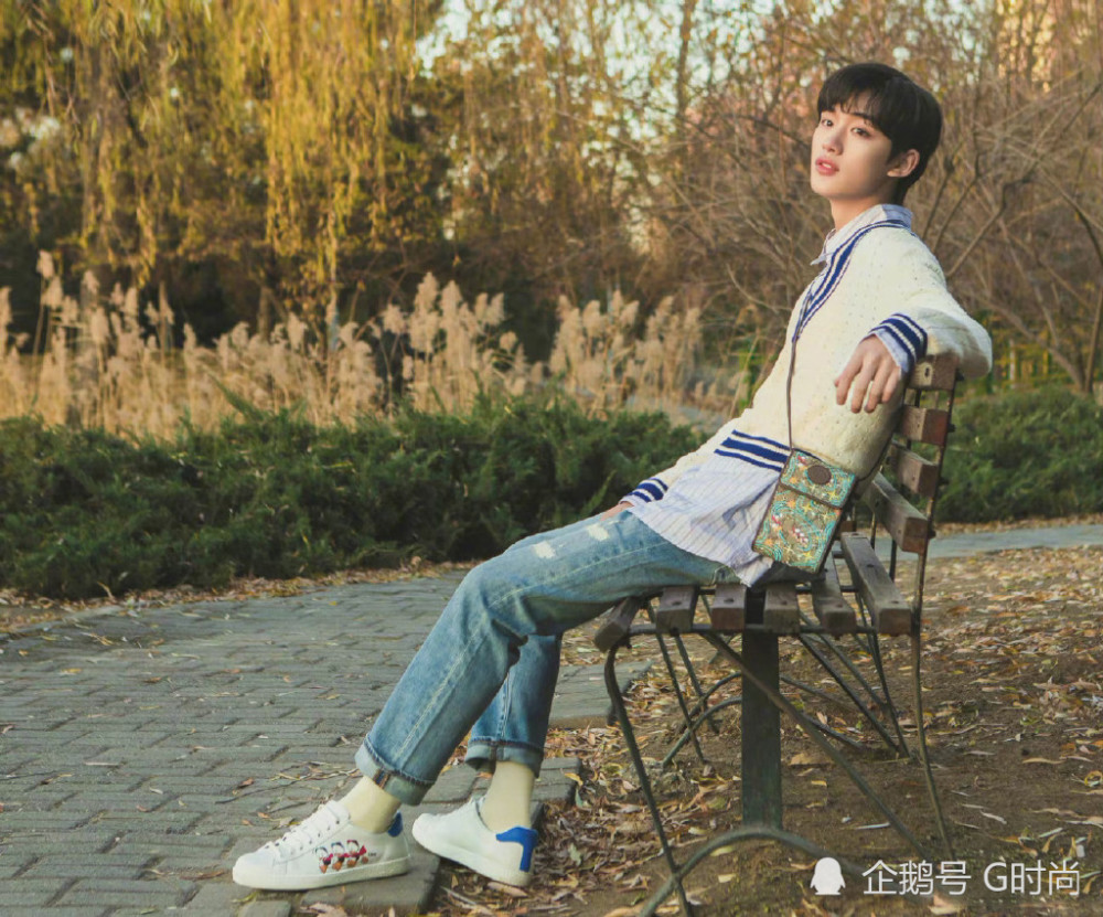 丁程鑫身着白色毛衣叠穿条纹衬衫,干净率性,搭配浅色牛仔裤更显活力