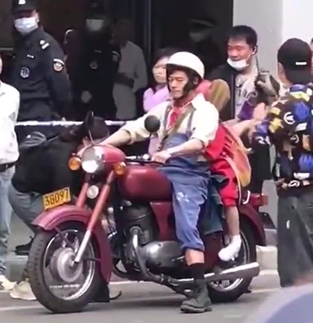 郭富城广州拍戏路透曝光,骑红色摩托,穿蓝色背带裤感