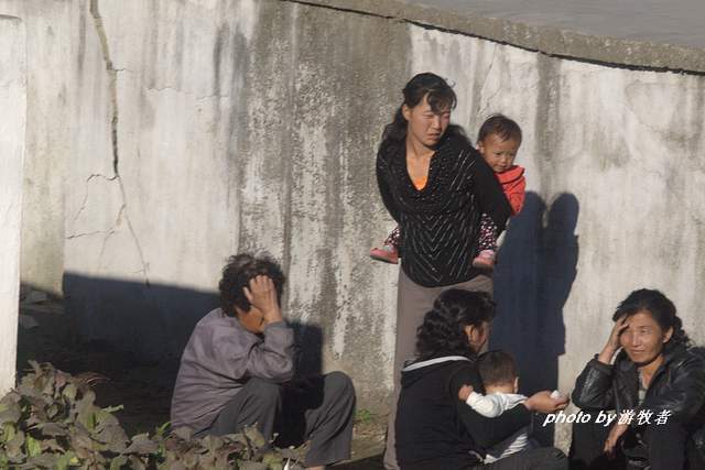 在朝鲜农村,村民们主要的交通工具就是自行车,一位妇女骑着自行车