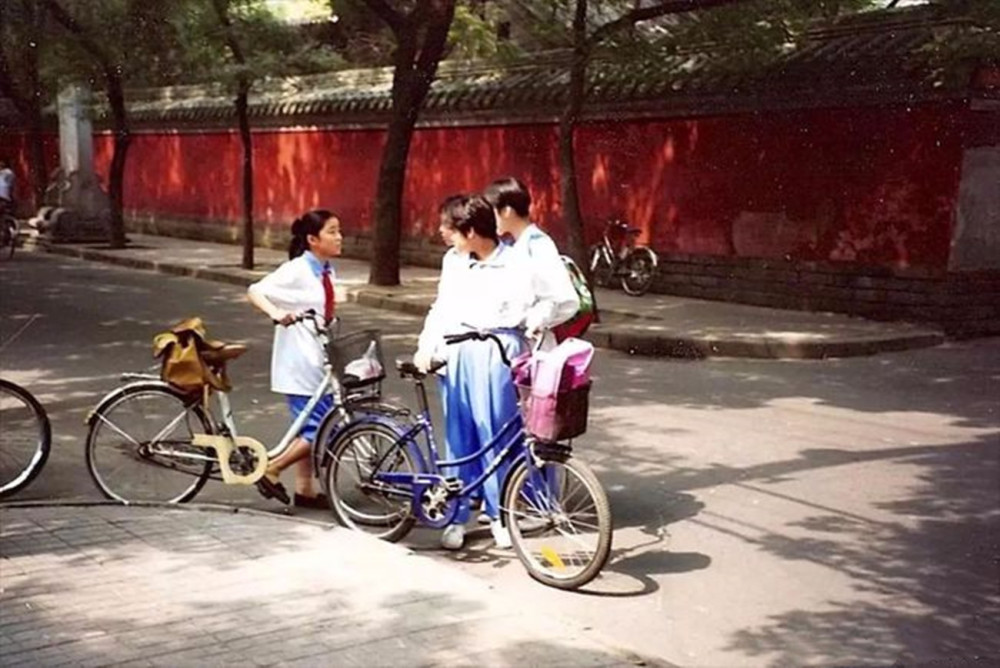 1990年代的北京城,穿着校服的中学生骑着自行车放学回家.