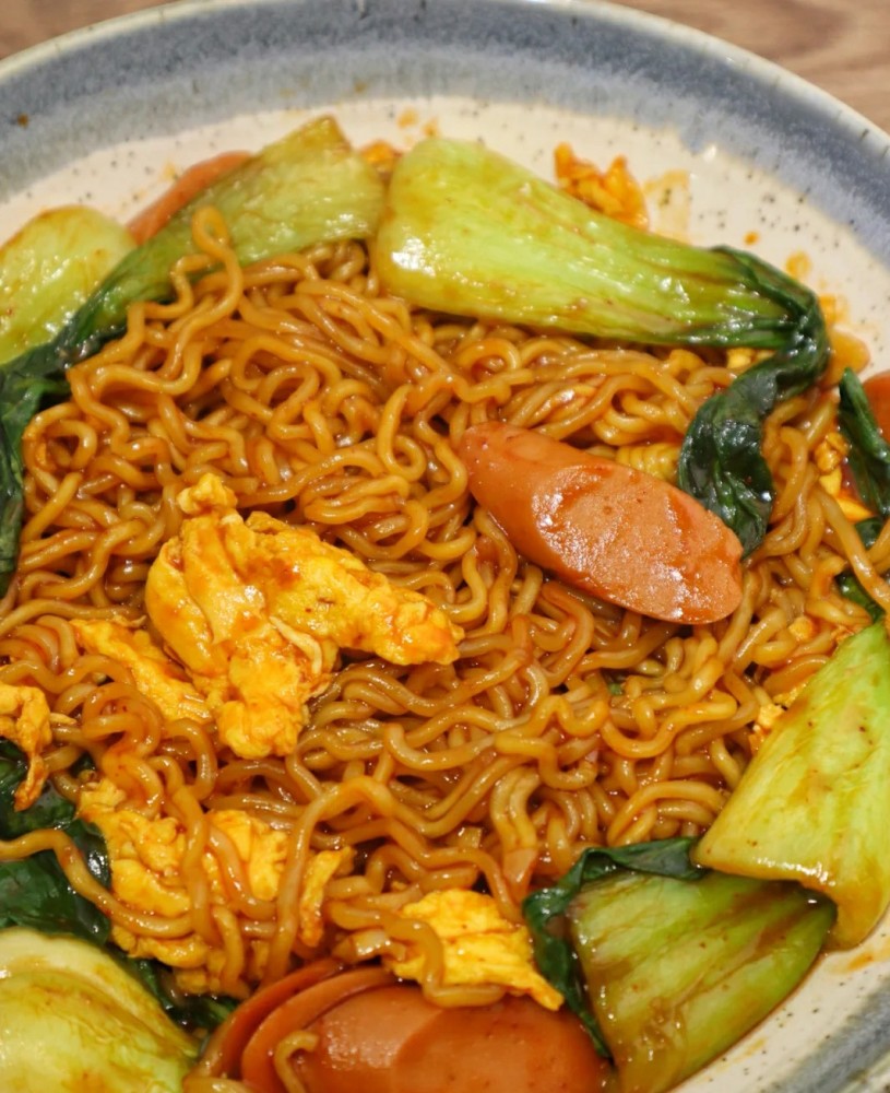 2:鸡蛋炒熟备用,爆香蒜末加入火腿肠上海青炒熟再加入煮熟的火鸡面