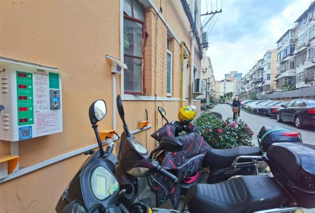 △门幢旁，电瓶车正在使用充电桩充电。