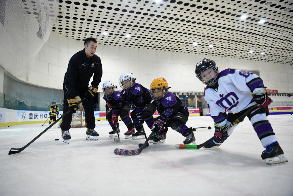 刘宏勋(左一)带领"hockey王子冰球队"队员进行热身训练(12月16日摄).