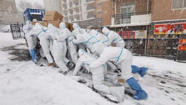 疫情中的感动瞬间:风雪中的志愿者艰难前行,1张背影图