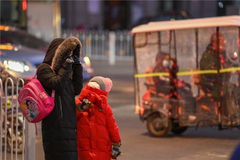 早上送孩子上学的家长和孩子都裹得严严实实.