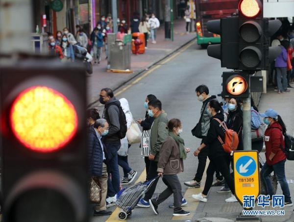 1月17日,在香港街头,香港市民戴口罩出行.新华社记者 李钢 摄