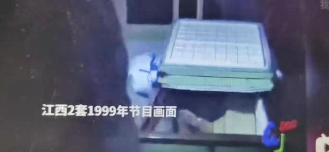 1999年的电视节目拍摄的案发现场,殷建华的尸体在床边的铁笼里,小木匠