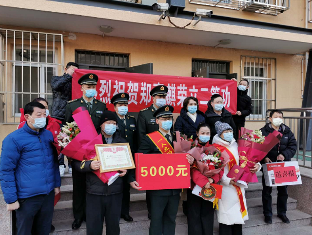 武装部,万寿路街道有关负责人手持"热烈祝贺郑嘉麒荣立二等功"的横幅