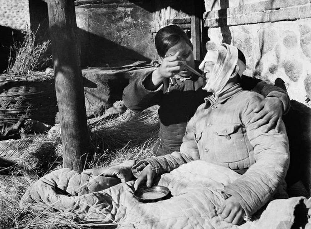 【女房东正给受伤的八路军喂汤药】1939年10月,冀中军区将60多名伤病