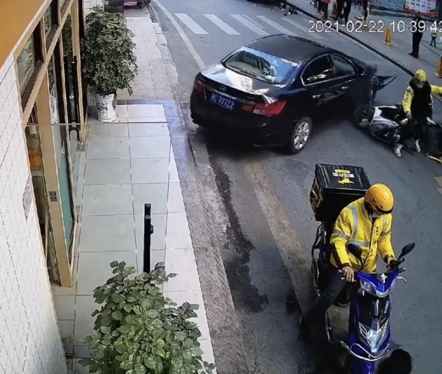 据事发地监控,女司机驾驶的黑色轿车在机动车道上突然拐着弯开启倒车