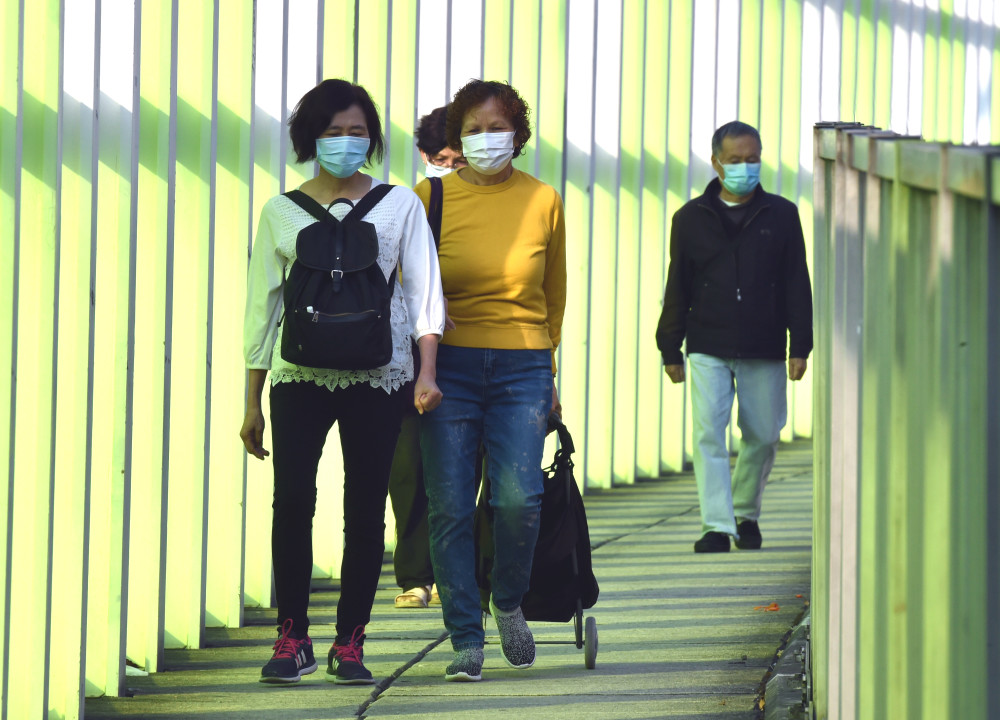 2月23日,香港市民佩戴口罩出行.新华社记者 卢炳辉 摄