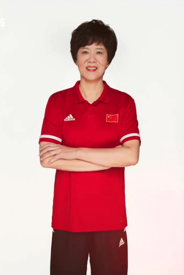 从照片可以看到,郎平穿着中国女排红色短袖队服,手持排球对着镜头比划