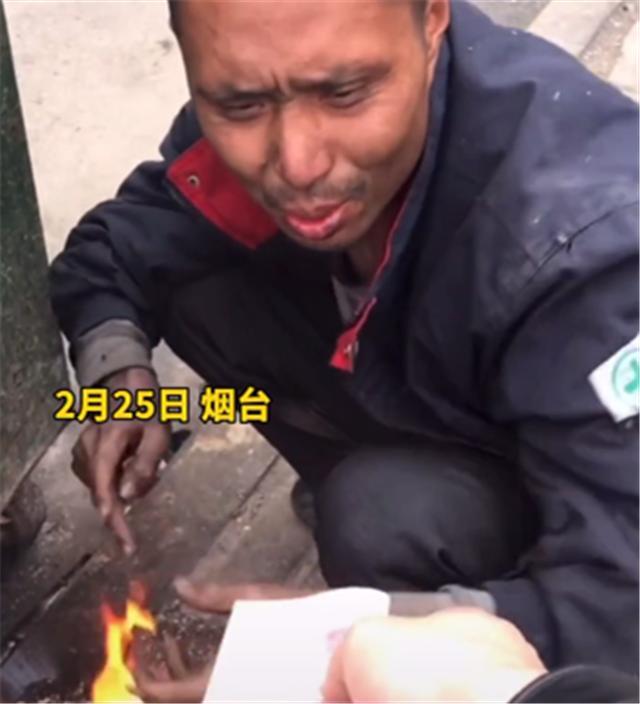 山东烟台,流浪汉路边烧火取暖,接过好心人施舍后跪下