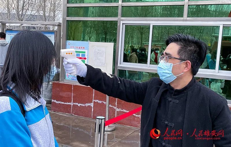 白洋淀高级中学校门口老师为每一位进门的学生测量体温.付振瑞/摄