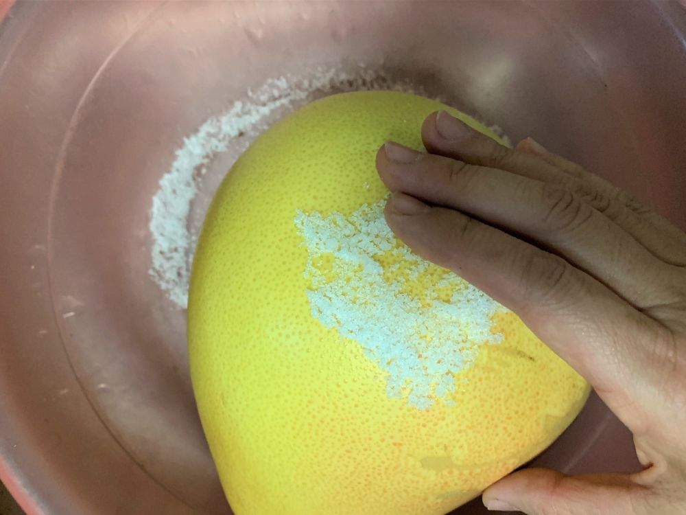 制作方法: 步骤1:先用食盐擦满柚子的整个外皮表面,不停地揉搓,再用