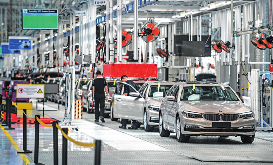 在沈阳华晨宝马大东工厂,工人在生产线上装配汽车