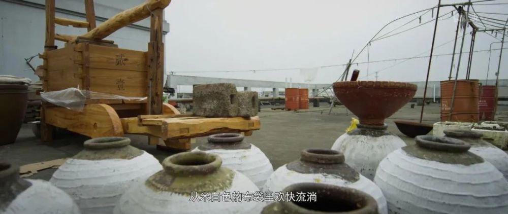 发酵后的米,装进布袋,摆在木榨上,另一侧压上千斤石,利用杠杆原理,榨