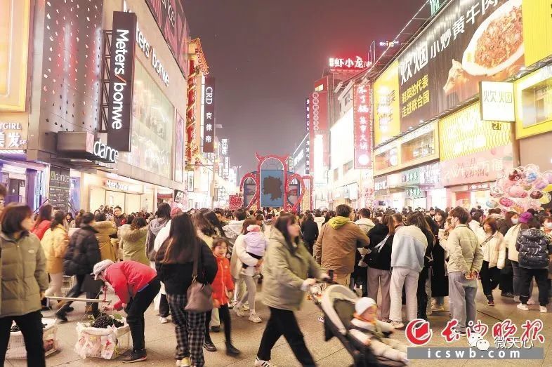 璀璨的霓虹灯之下人来人往,网红小吃店里的长沙特色美食飘香,街头艺人