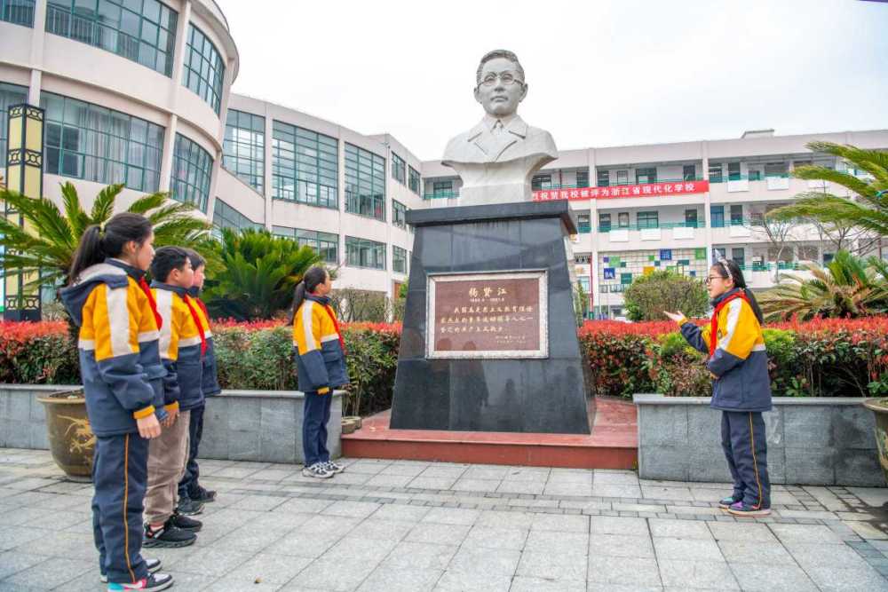 泗门镇中心小学杨贤江雕像前,小讲解员正在向同学讲述杨贤江的故事.