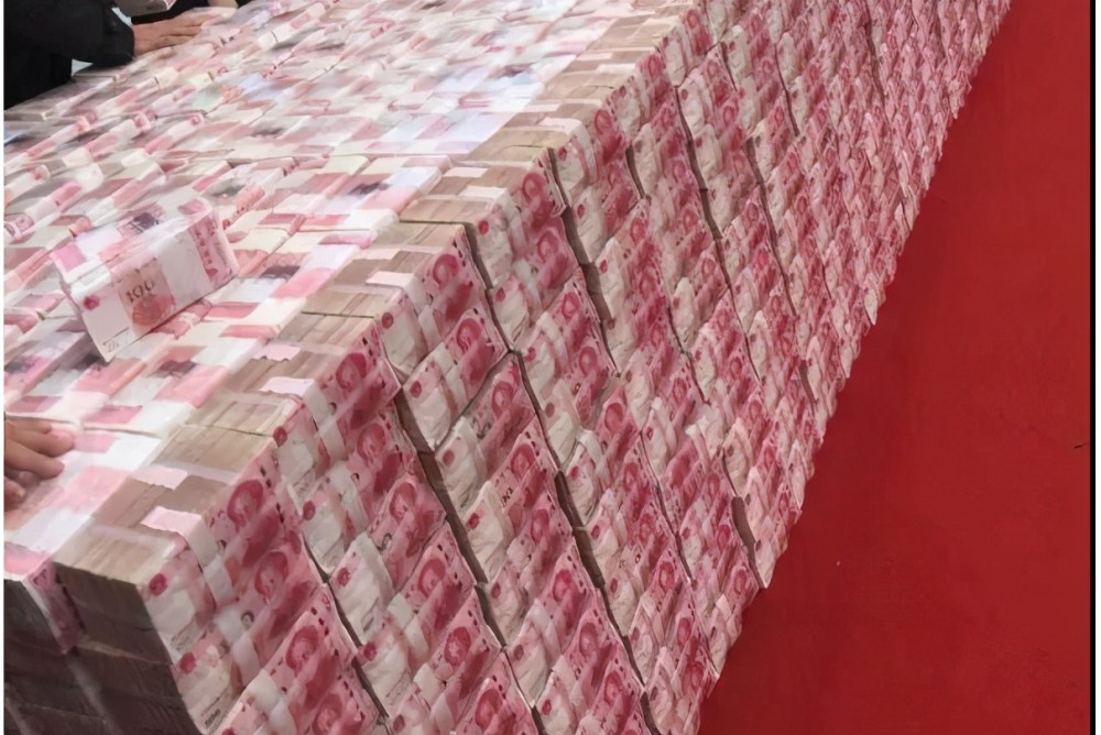 在新闻镜头下,一摞摞红彤彤的百元大钞就像小山一般被放置在中贤台村